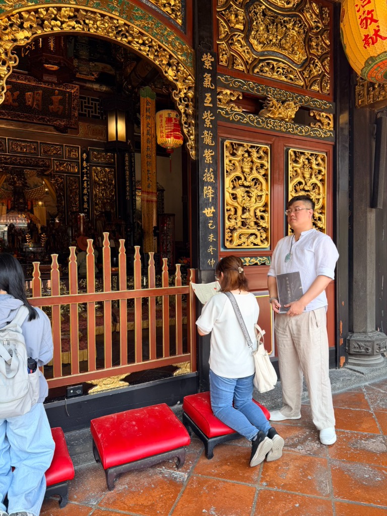 解命師玅曄在牌坊前閱讀普門品